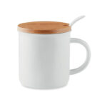 Mug en porcelaine avec une cuillère et couvercle en bambou. Boîte individuelle. La tampographie ne résiste pas au lave-vaisselle. Le transfert en céramique résiste au lave-vaisselle. Capacité 380 ml.Le bambou est un produit naturel