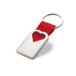 Porte clef en métal de finition satinée avec une décoration en creux en forme de coeur. L'anneau est attaché par un ruban de couleur rouge en polyester. Boite cadeau individuelle.-Rouge-8719941003743